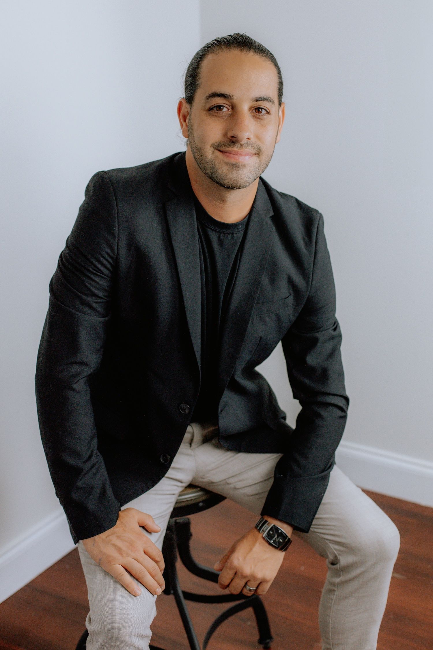 A woman is sitting at a desk with a laptop and a vase of flowers.