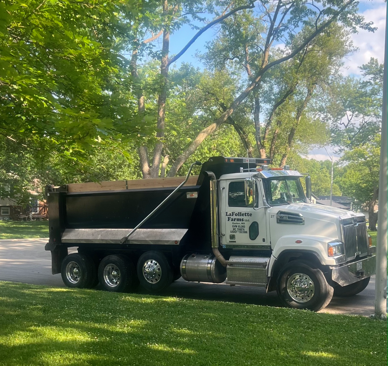 White dump truck parked on a residential street.