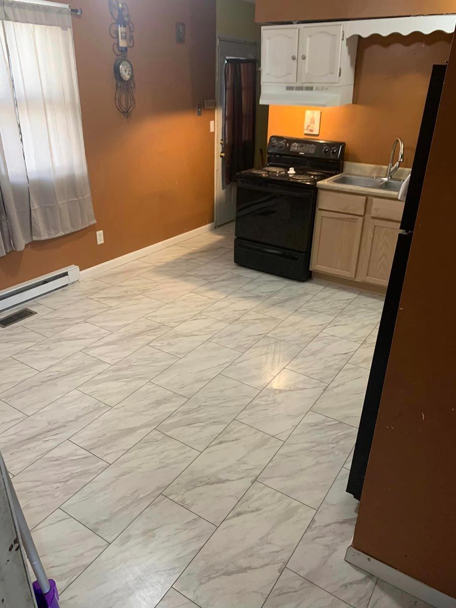 A kitchen with a stove, refrigerator, sink and cabinets located in Mahomet, IL.