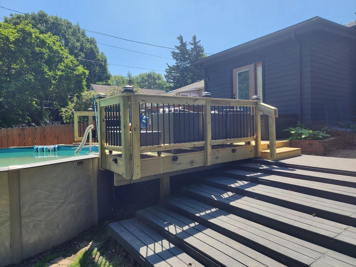 A wooden deck overlooking a pool next to a house located in Danville, IL.