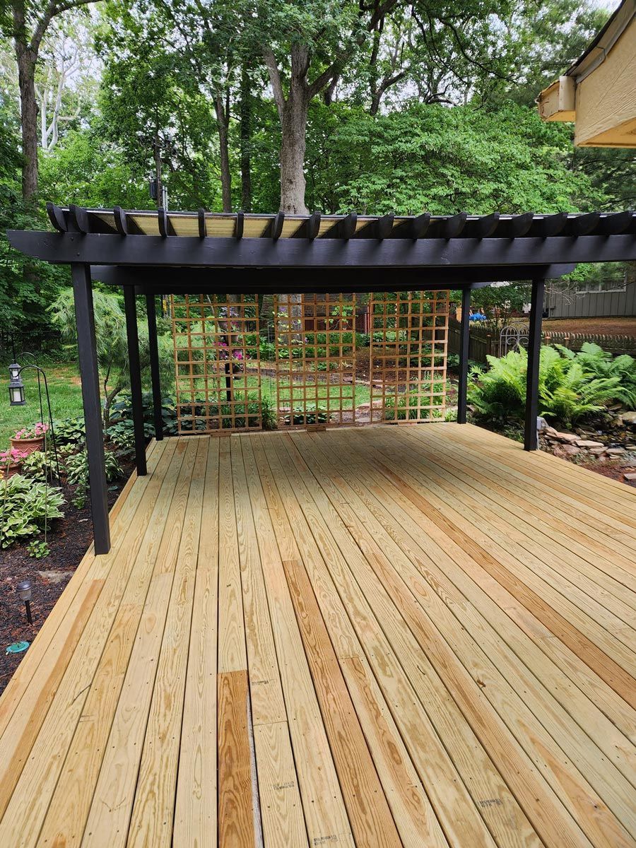 A wooden deck with a pergola on top of it located in Urbana, IL.