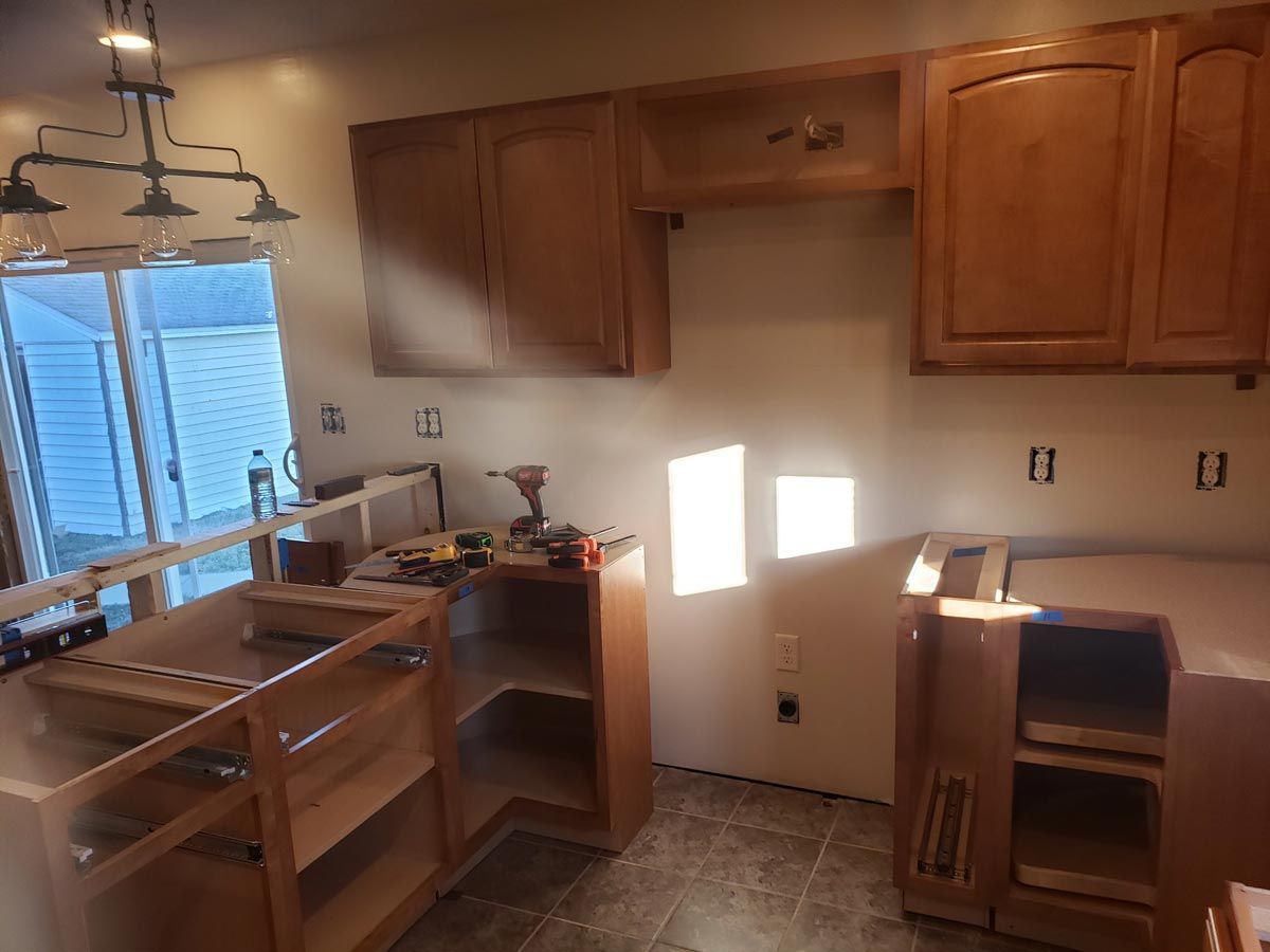 A kitchen with wooden cabinets and a stove top oven located in Mahomet, IL.