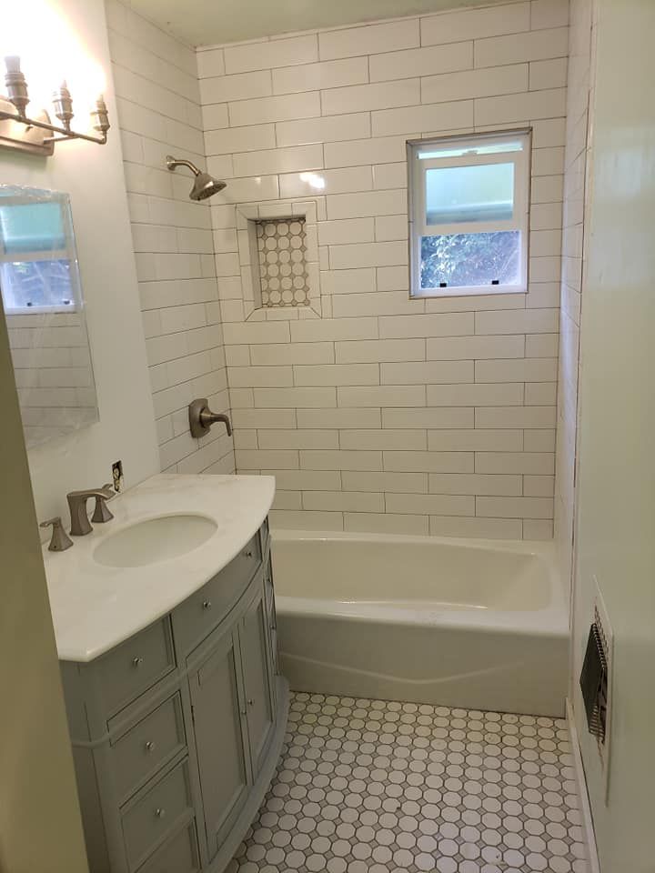 A bathroom with a sink, tub, shower and window located Urbana, IL