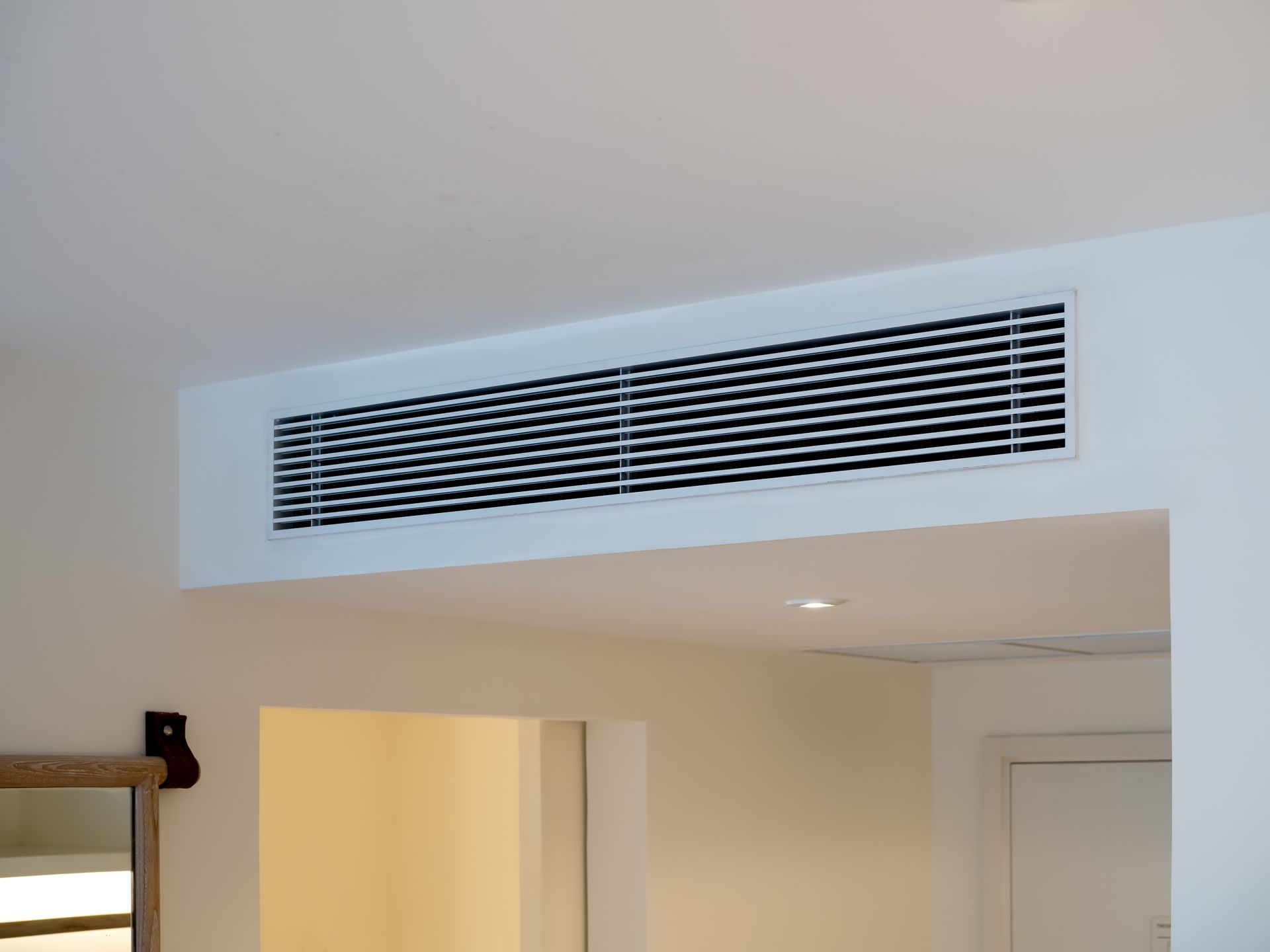 A white ceiling with a black grille on it