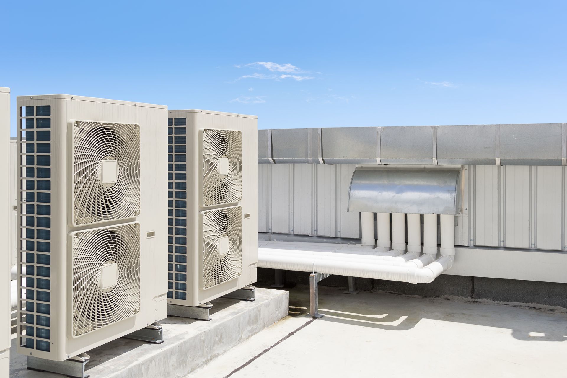 There are two air conditioners on the roof of a building.