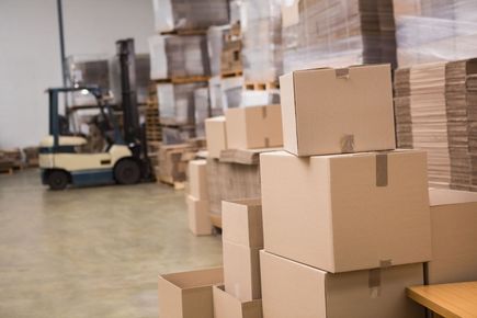 Warehouse scene with stacked cardboard boxes, forklift, and packed pallets.