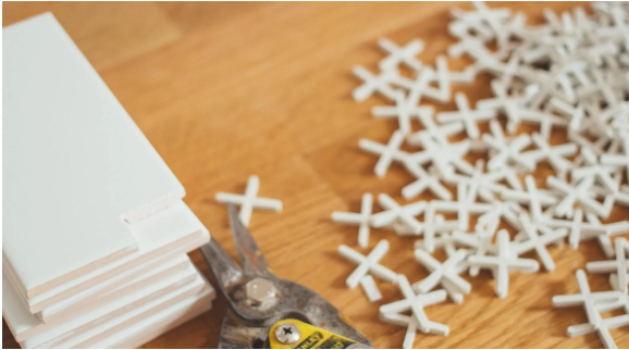 White Cut tiles along with a tile cutter and white grout spacers