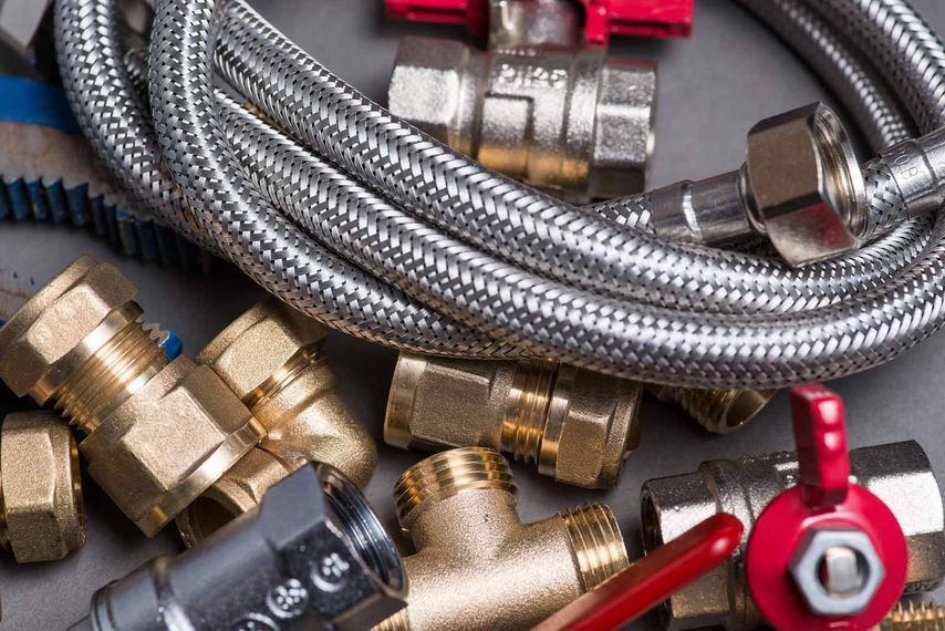 A close up of a hose , valves , and fittings on a table.