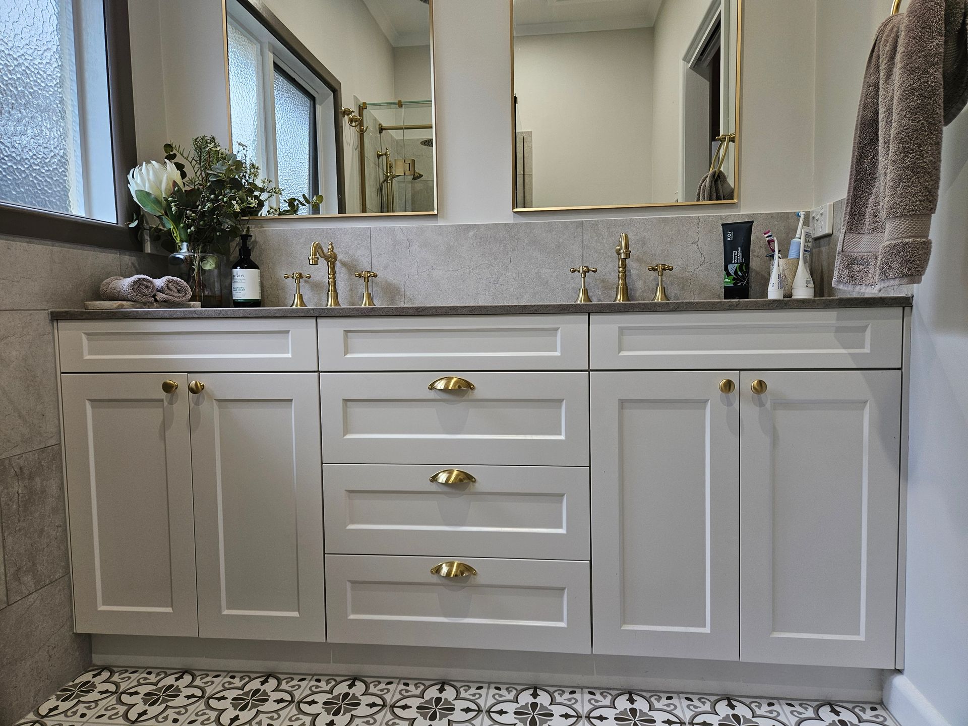 A bathroom with two sinks and a large mirror