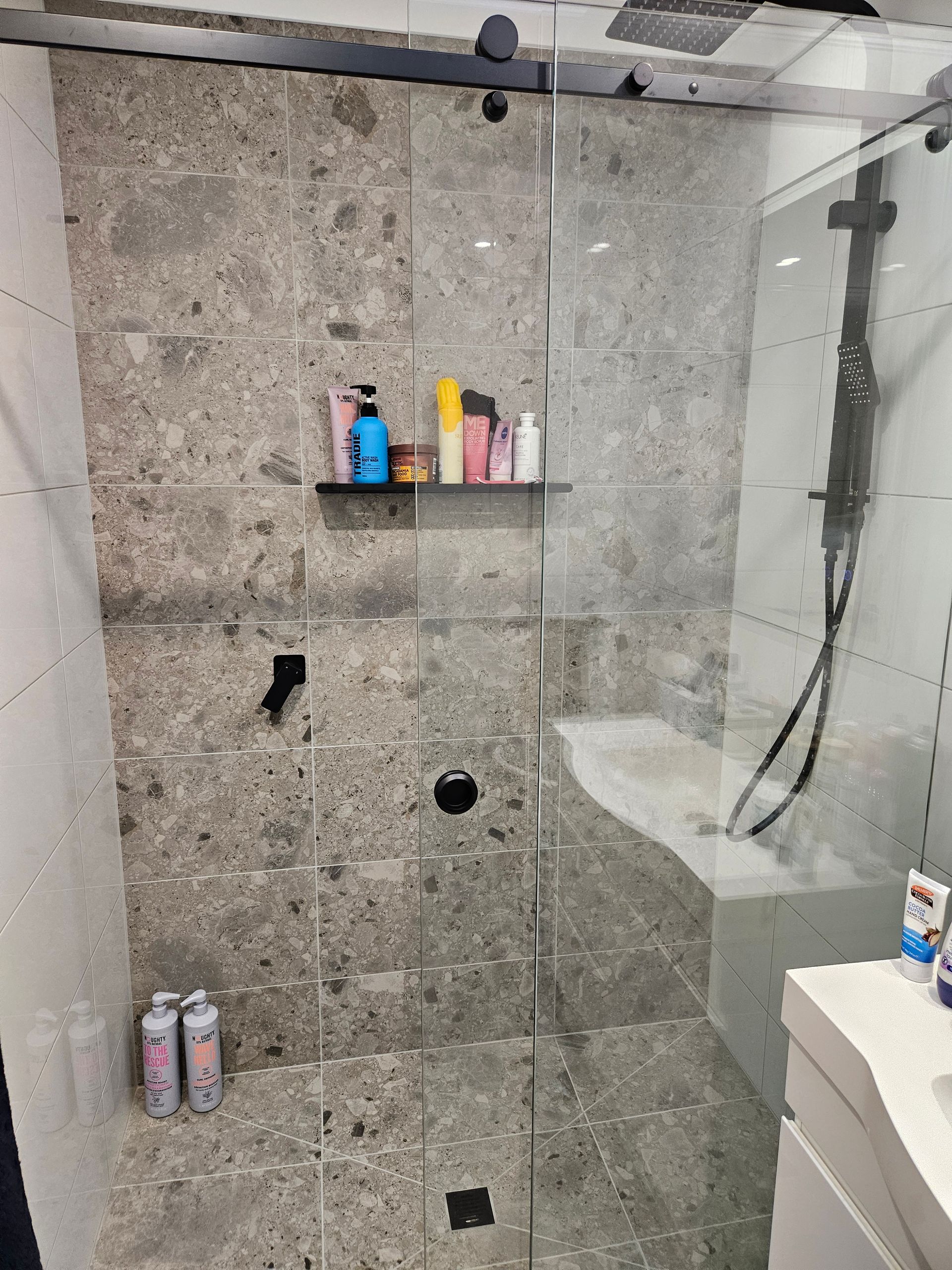 A bathroom with a sliding glass shower door and a sink.