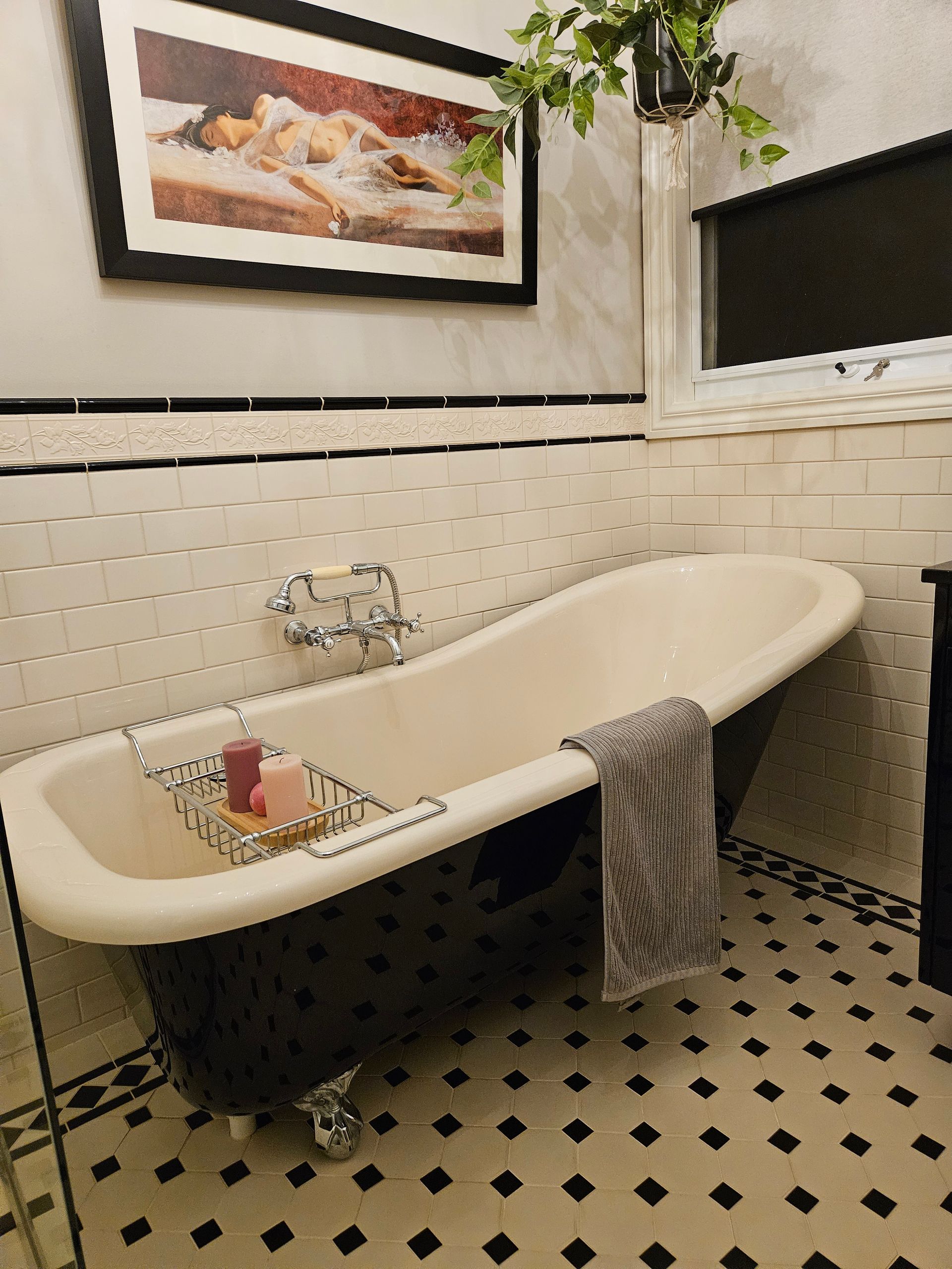 A bathtub in a bathroom with a picture on the wall above it