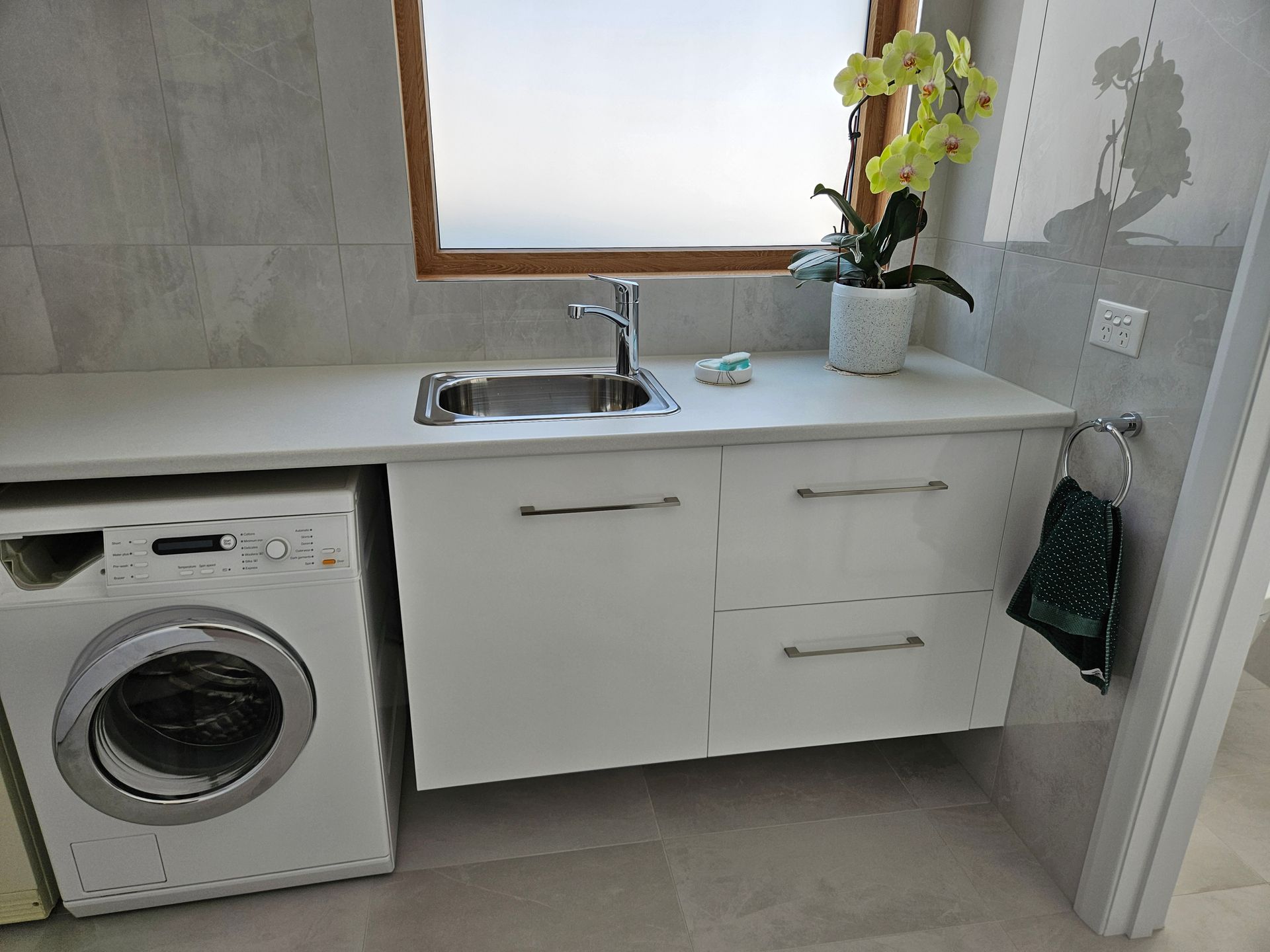 A laundry room with a washer and dryer and a sink