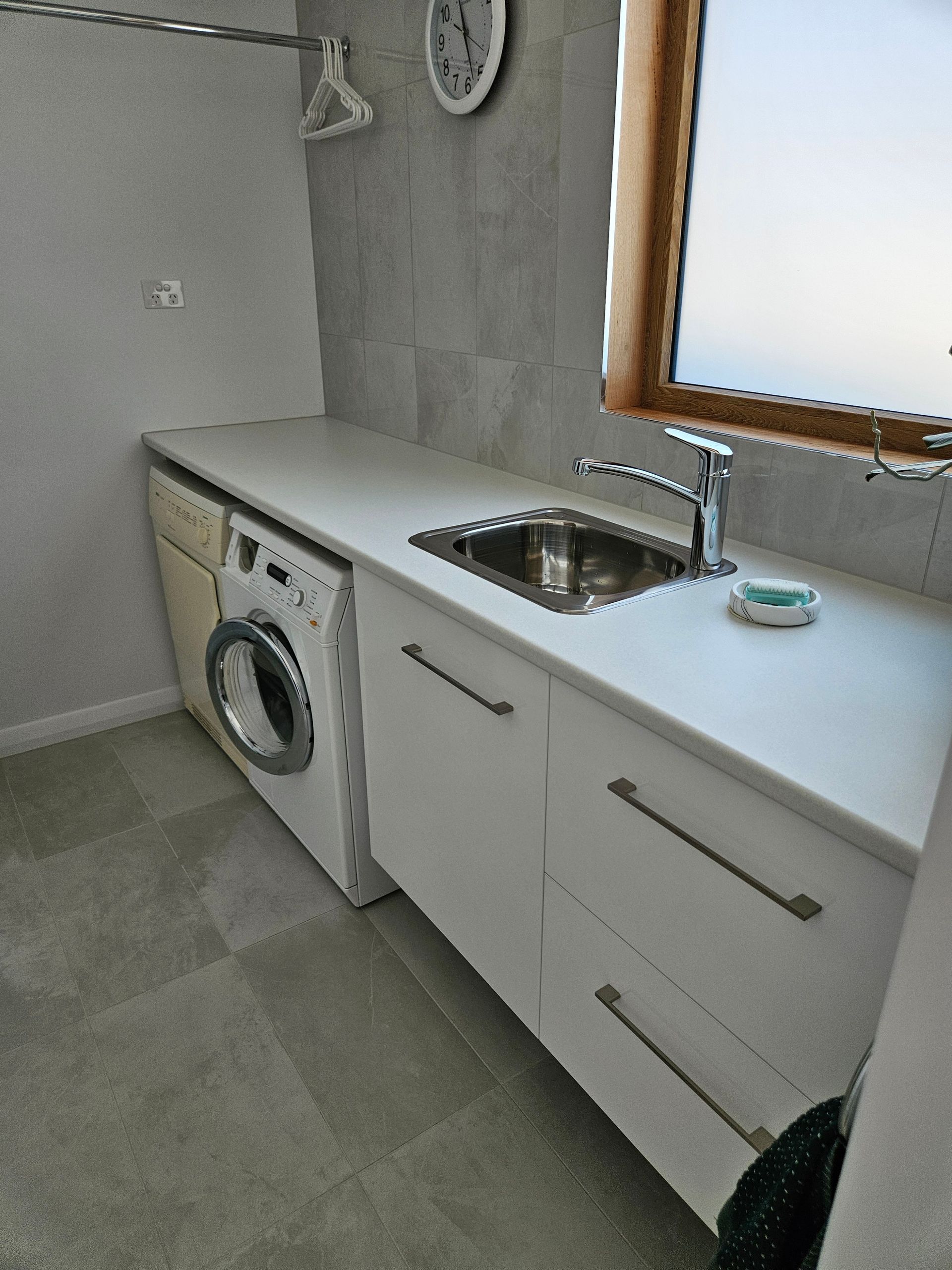 A laundry room with a washer and dryer and a sink