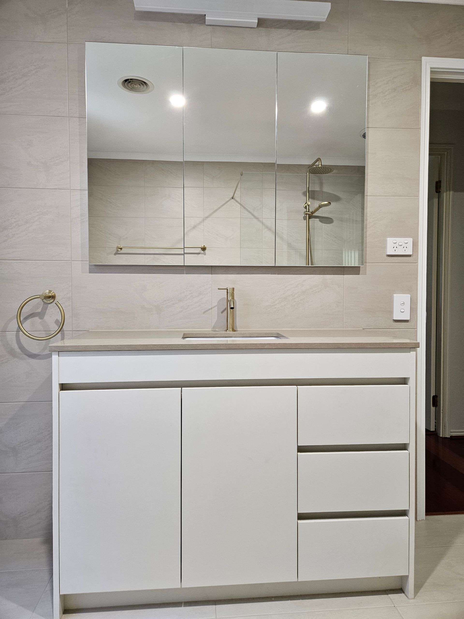 A bathroom with a sink , mirror and cabinets.