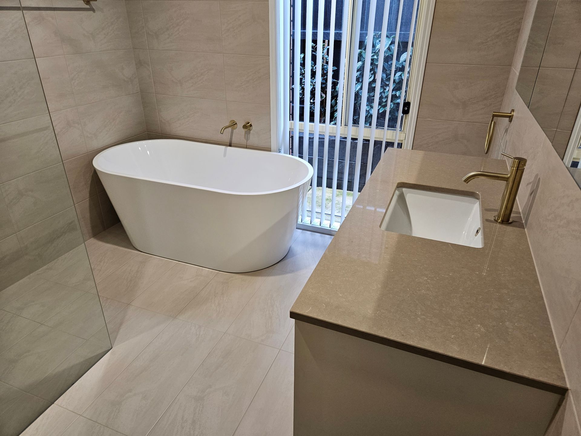 A bathroom with a bathtub , sink and shower.