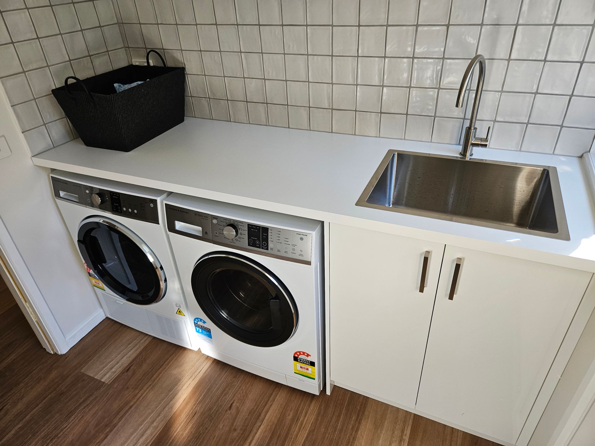 A laundry room with a washer and dryer and a sink.