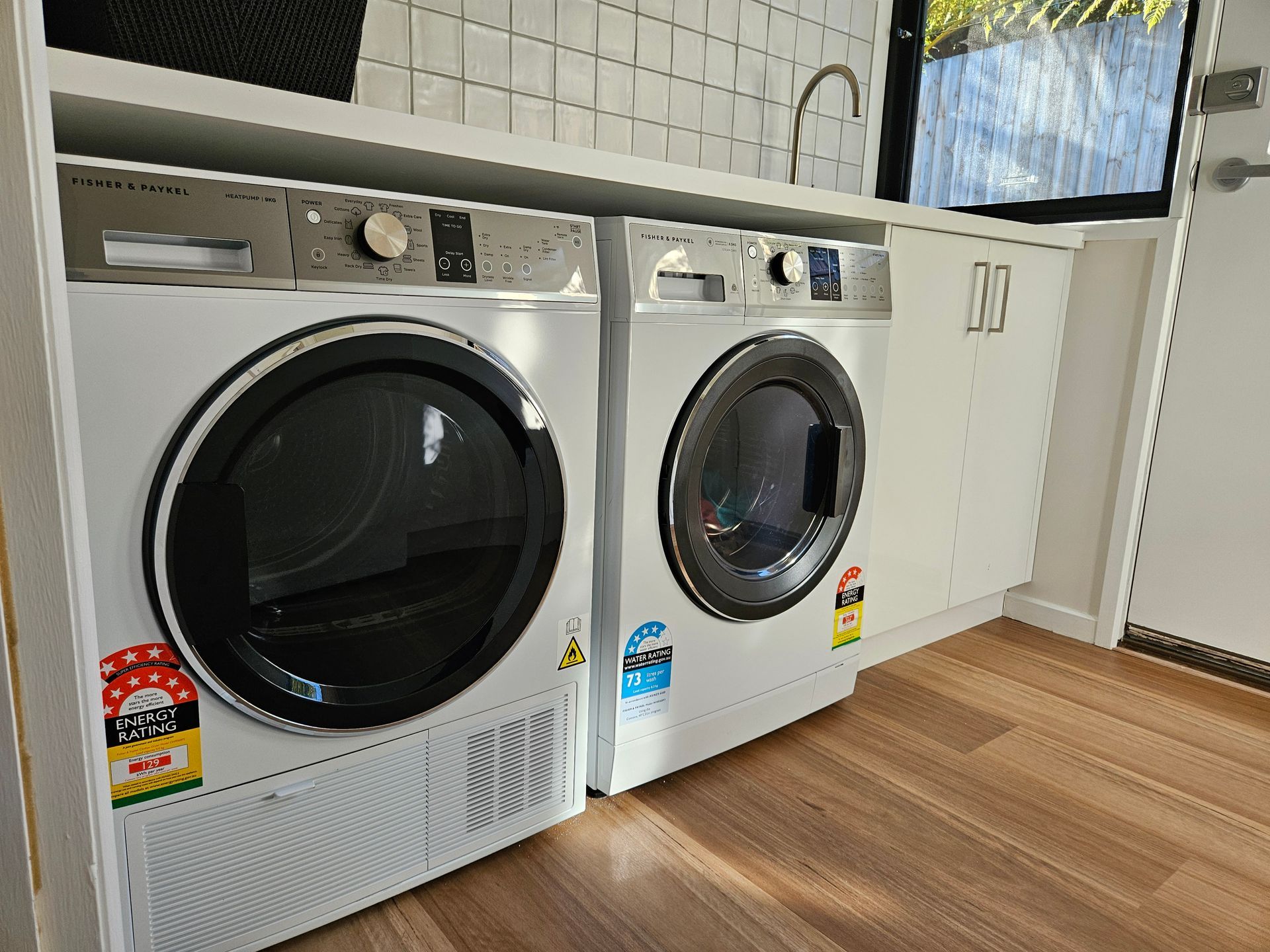 A washer and dryer are sitting next to each other in a laundry room.