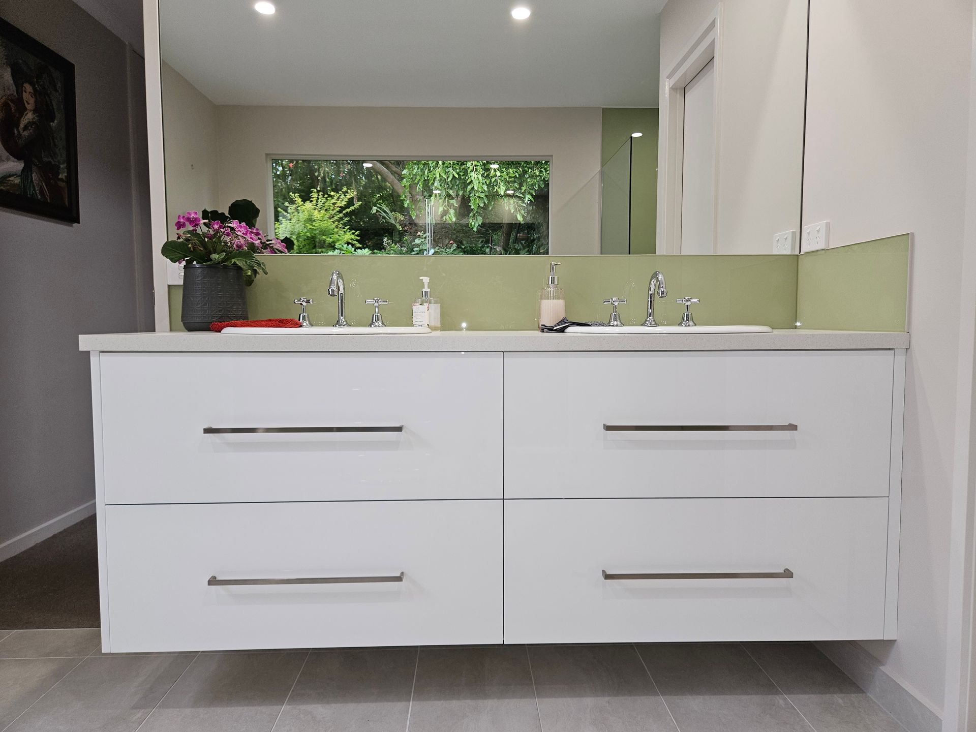 A bathroom with two sinks and a large mirror