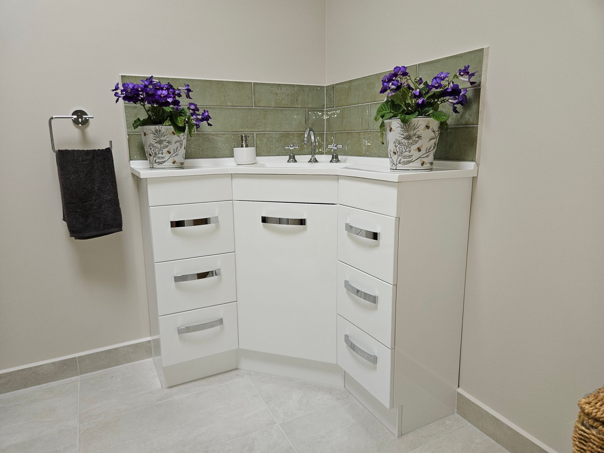 A bathroom with a sink and purple flowers on the counter