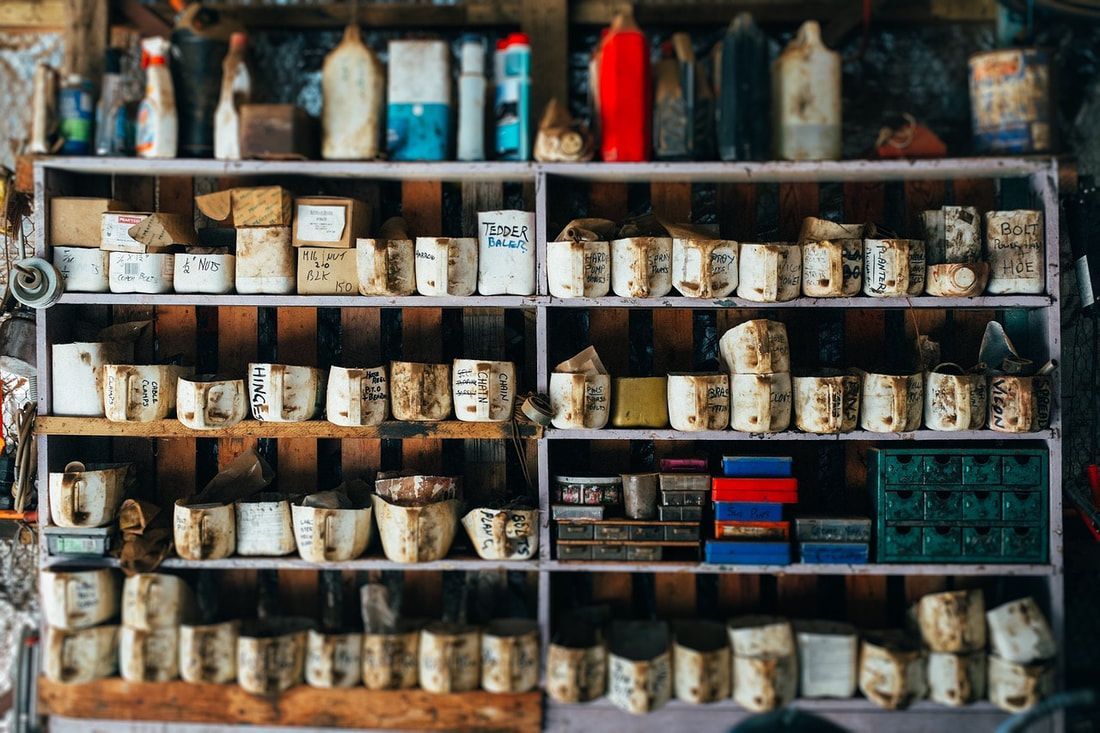 Shelves filled with various aged, white ceramic containers, and bottles.