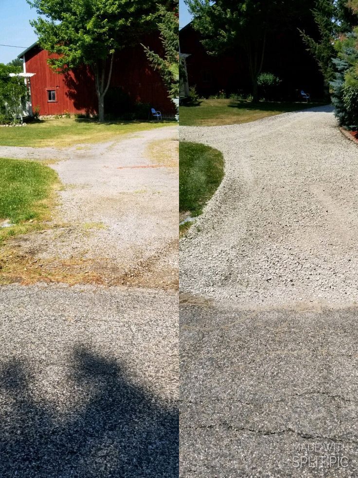 Gravel driveway curving past a red barn and grassy yard. Sunlight casts shadows on the driveway.