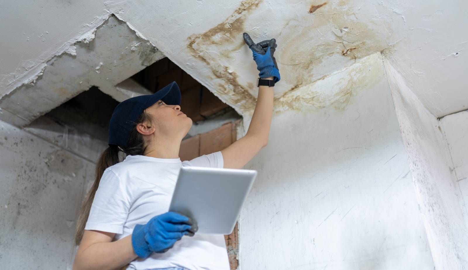 A homeowner examining water damage in their basement, assessing the extent and planning DIY cleanup 