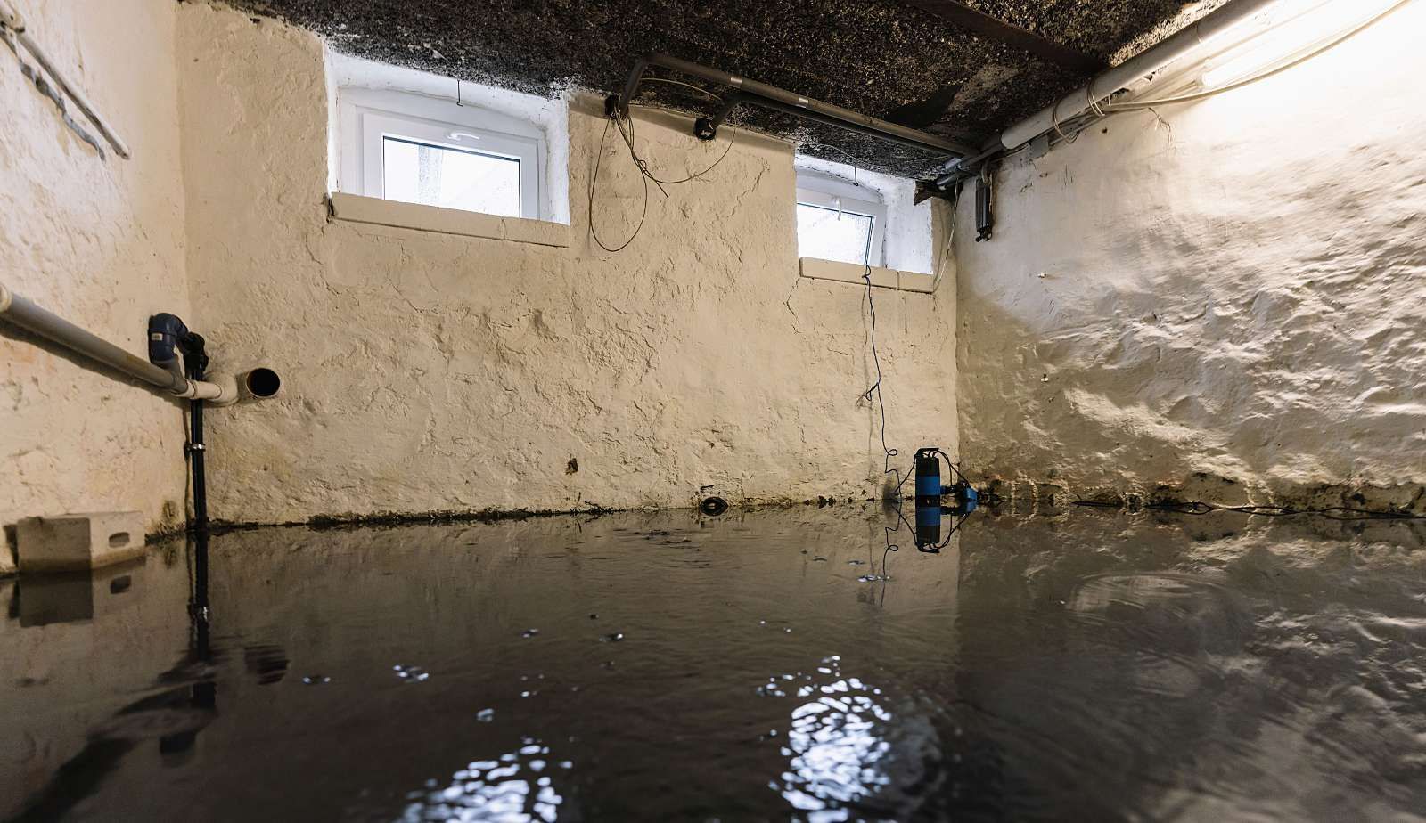A flooded room with a door open and a dirty floor.