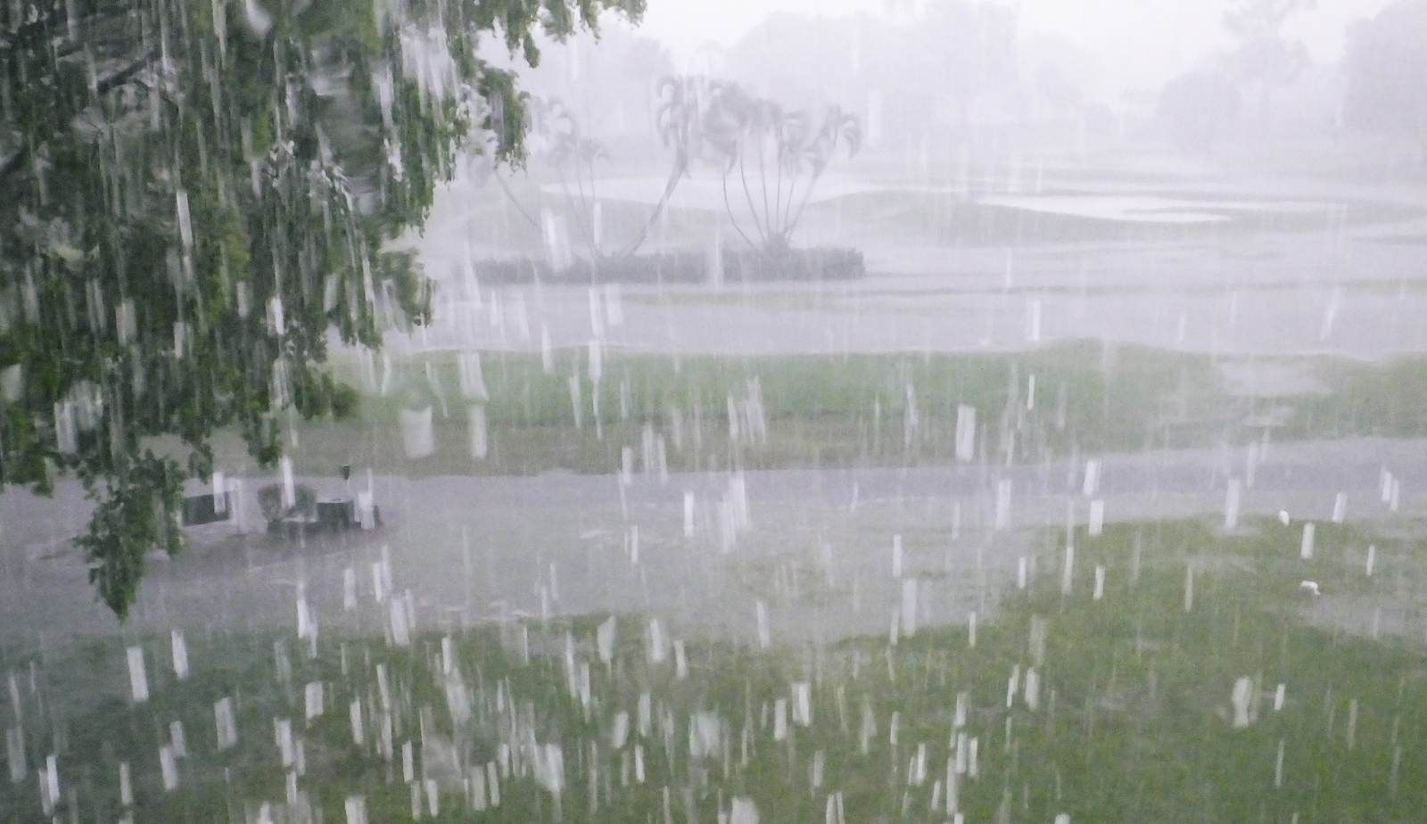 A water-filled basement with soaked flooring and furniture, showing the aftermath of sudden storm runoff entering a home.