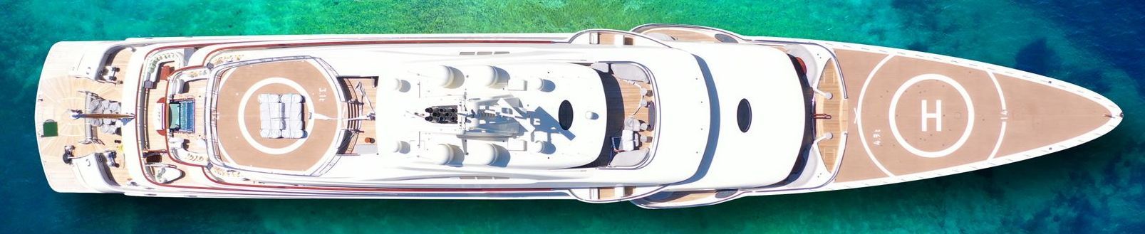 ariel view of a large 50m modern white superyacht on turquoise sea