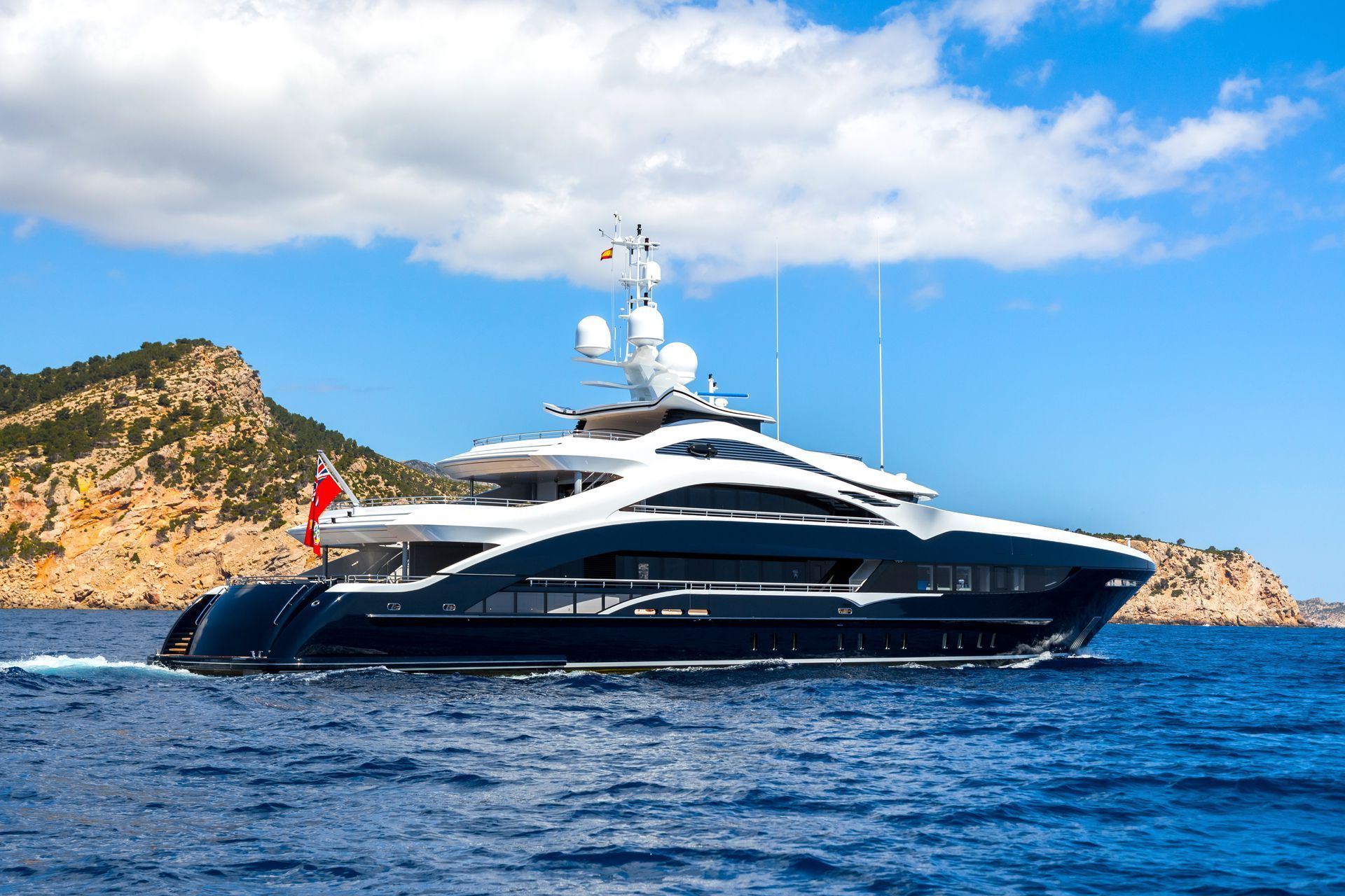 large blue and white superyacht flying the Red Ensign