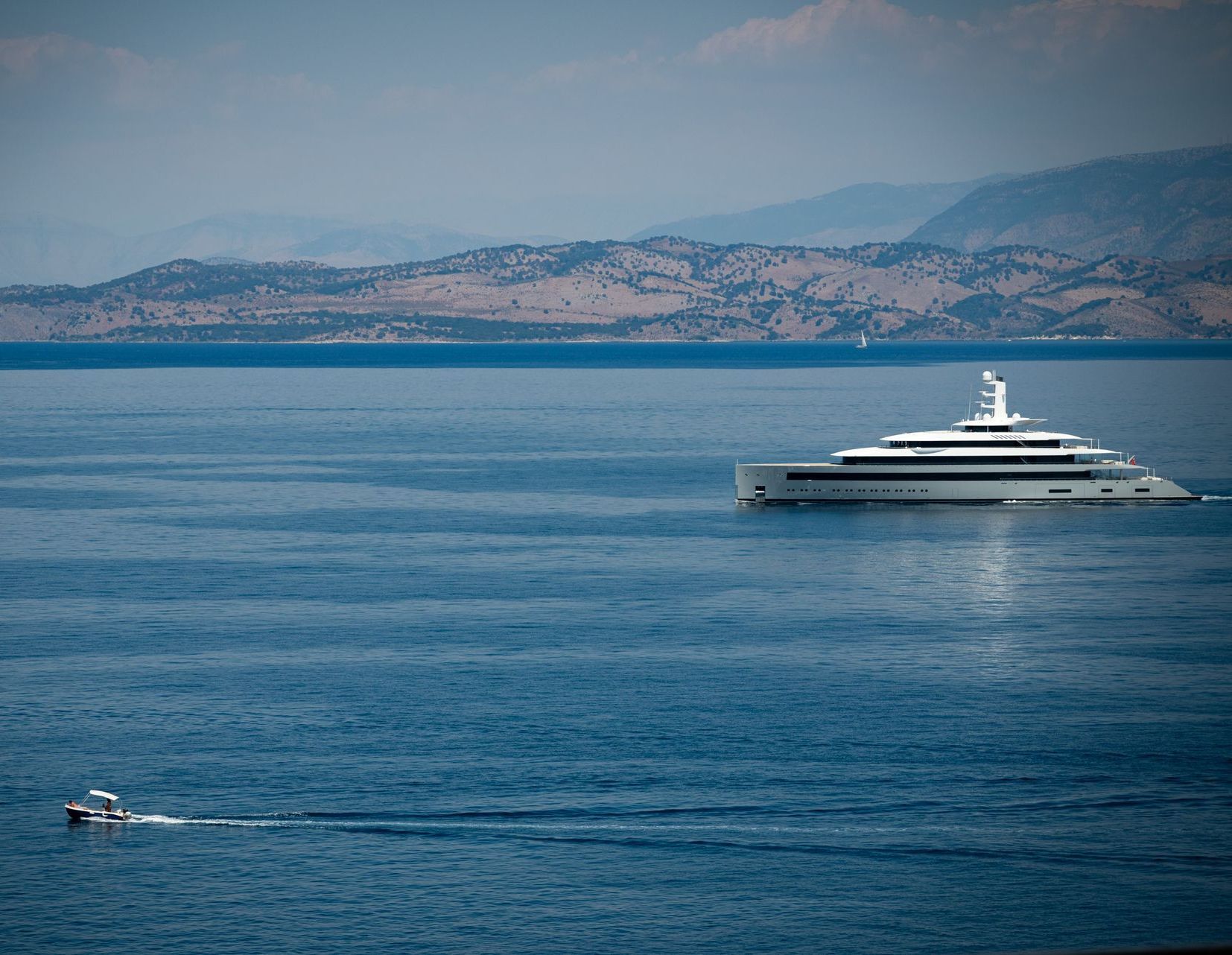 large 50m+ modern white superyacht sails calm seas off Corfu