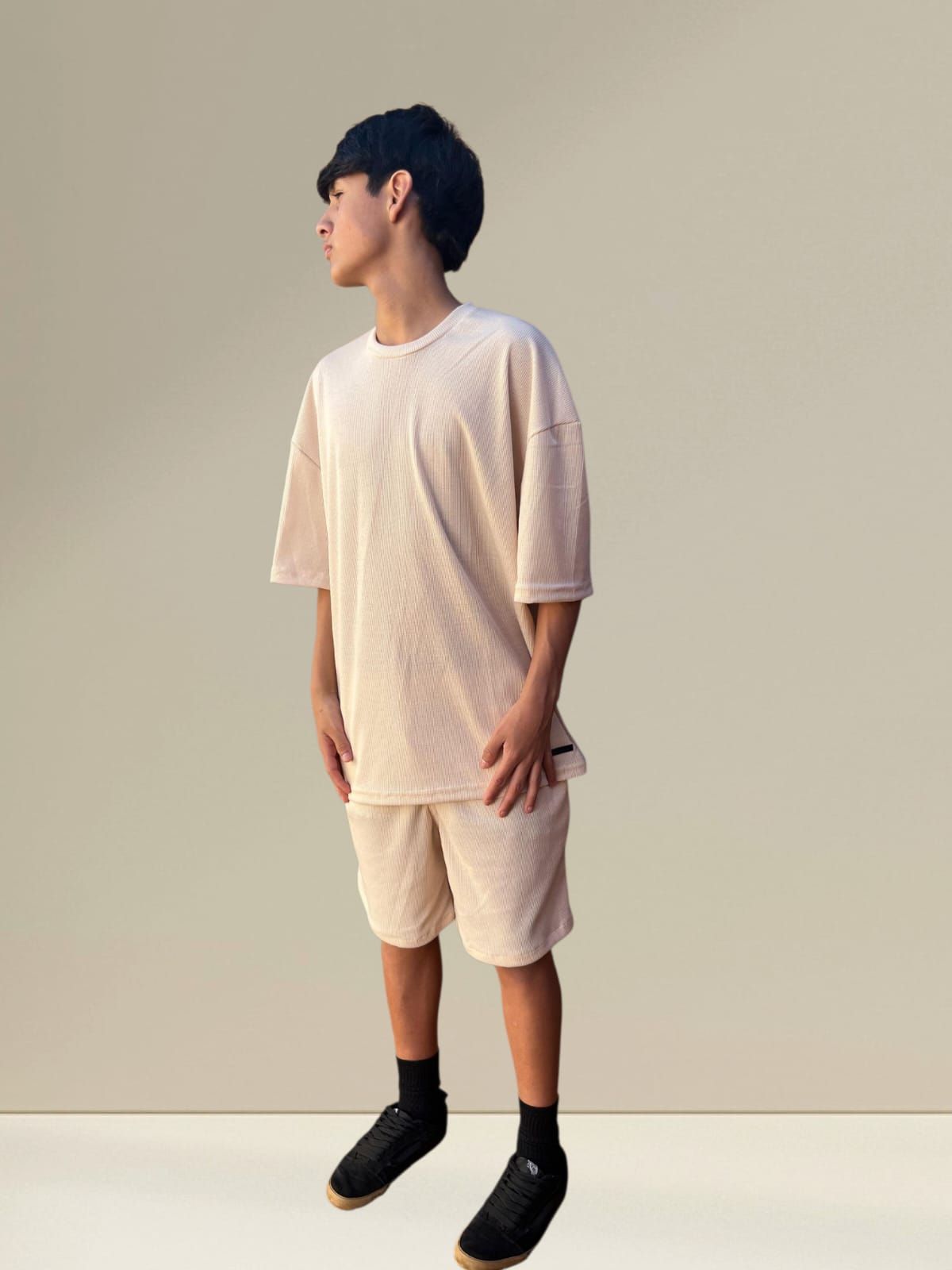 Persona vestida con un conjunto de camiseta y pantalones cortos a juego de color beige claro.