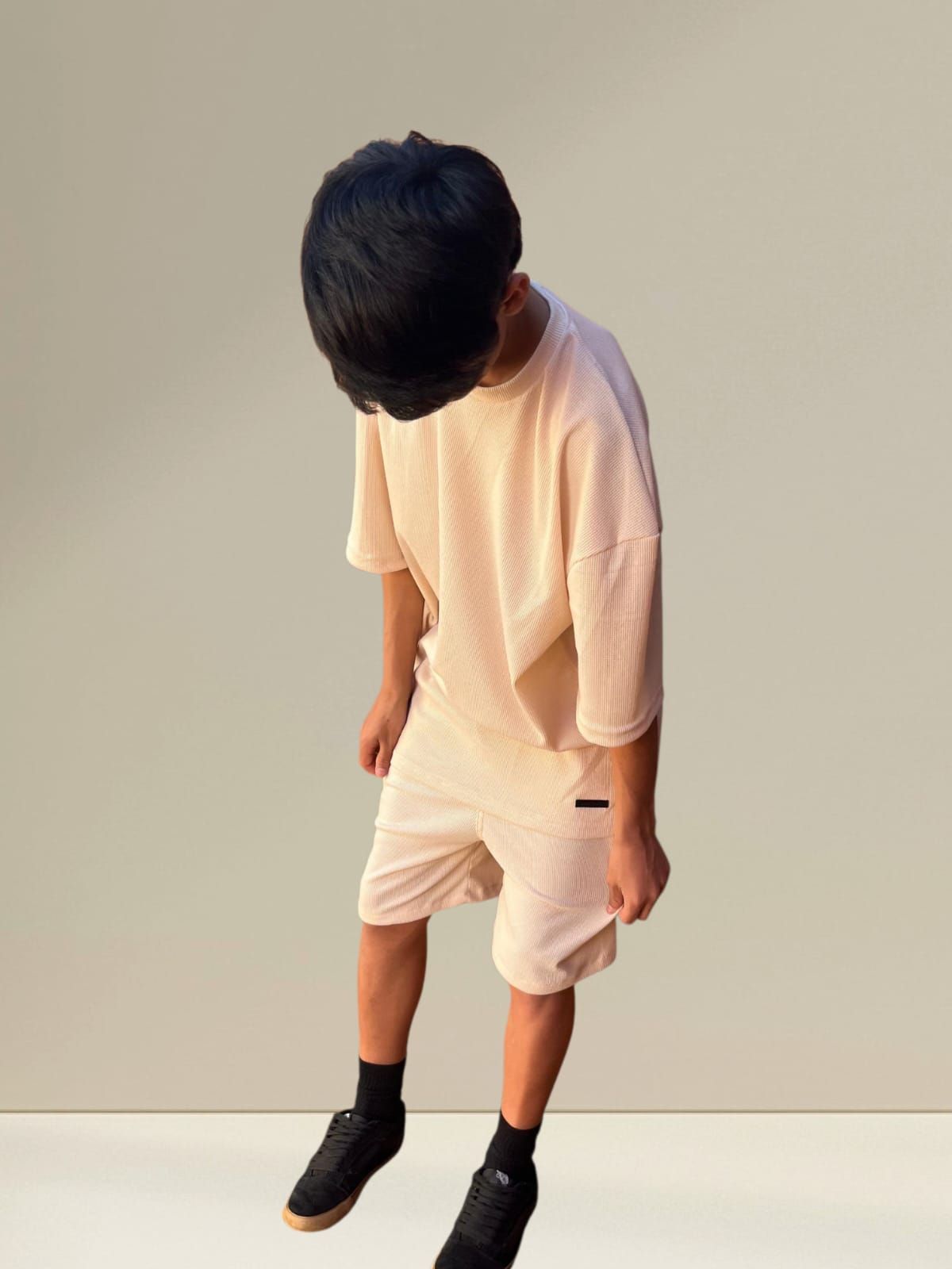 Persona vestida con un conjunto de camiseta y pantalones cortos a juego de color beige claro.