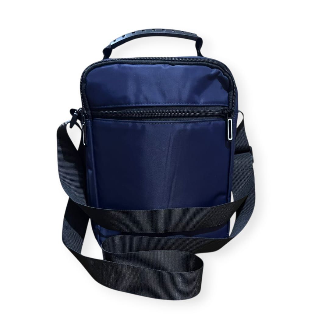 Bolso bandolera azul marino con correa para el hombro y asa superior.