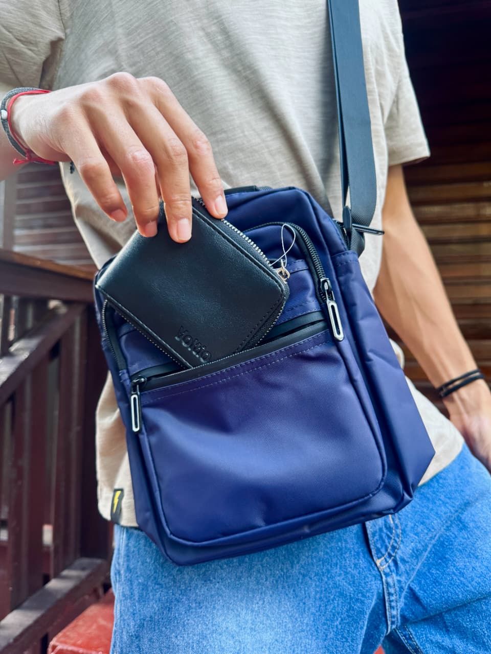 Cartera de piel negra con cierre de cremallera.