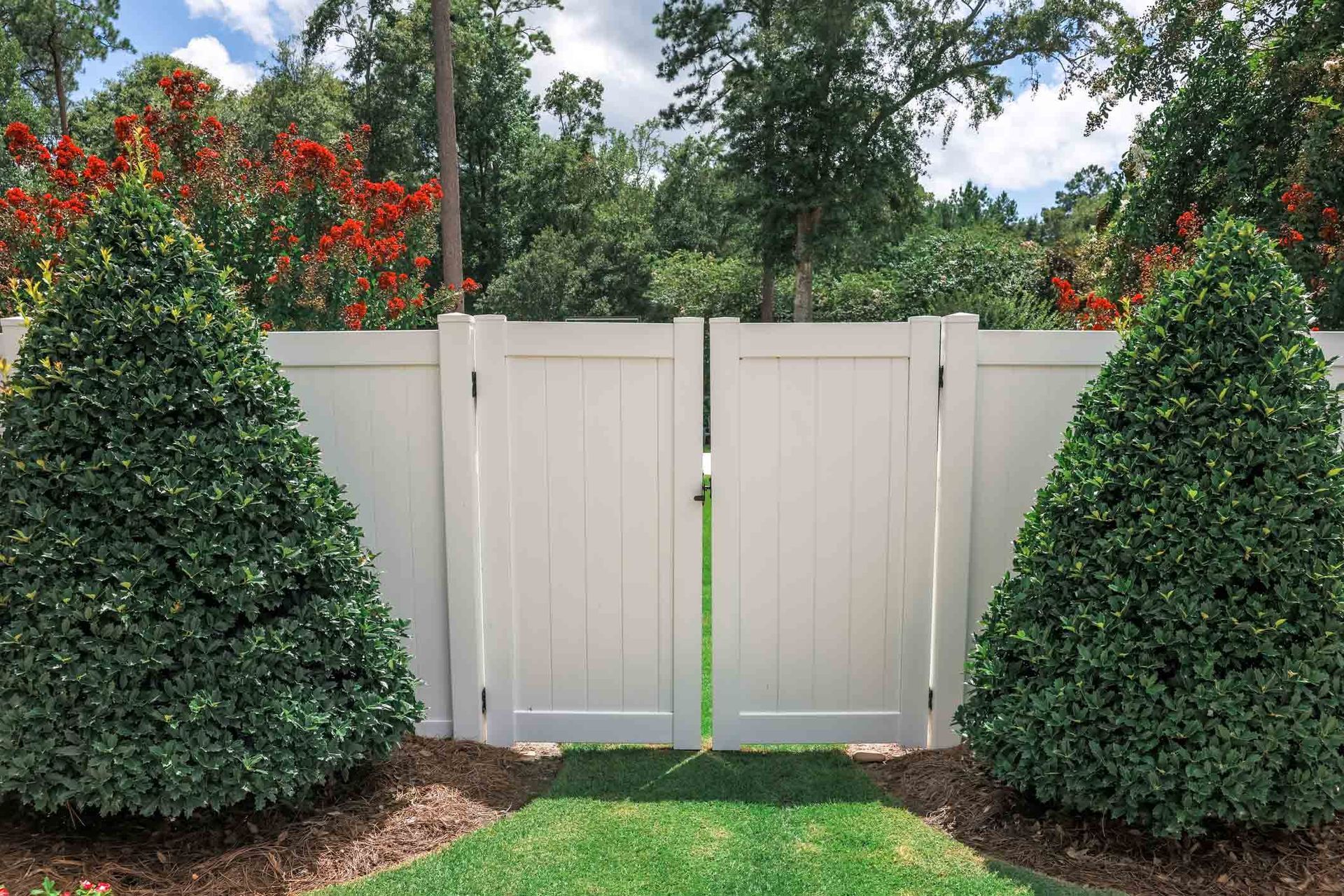 A White Fence with A Gate and Bushes in Front of It | Cranbourne, VIC | Cranbourne Fencing Pty Ltd