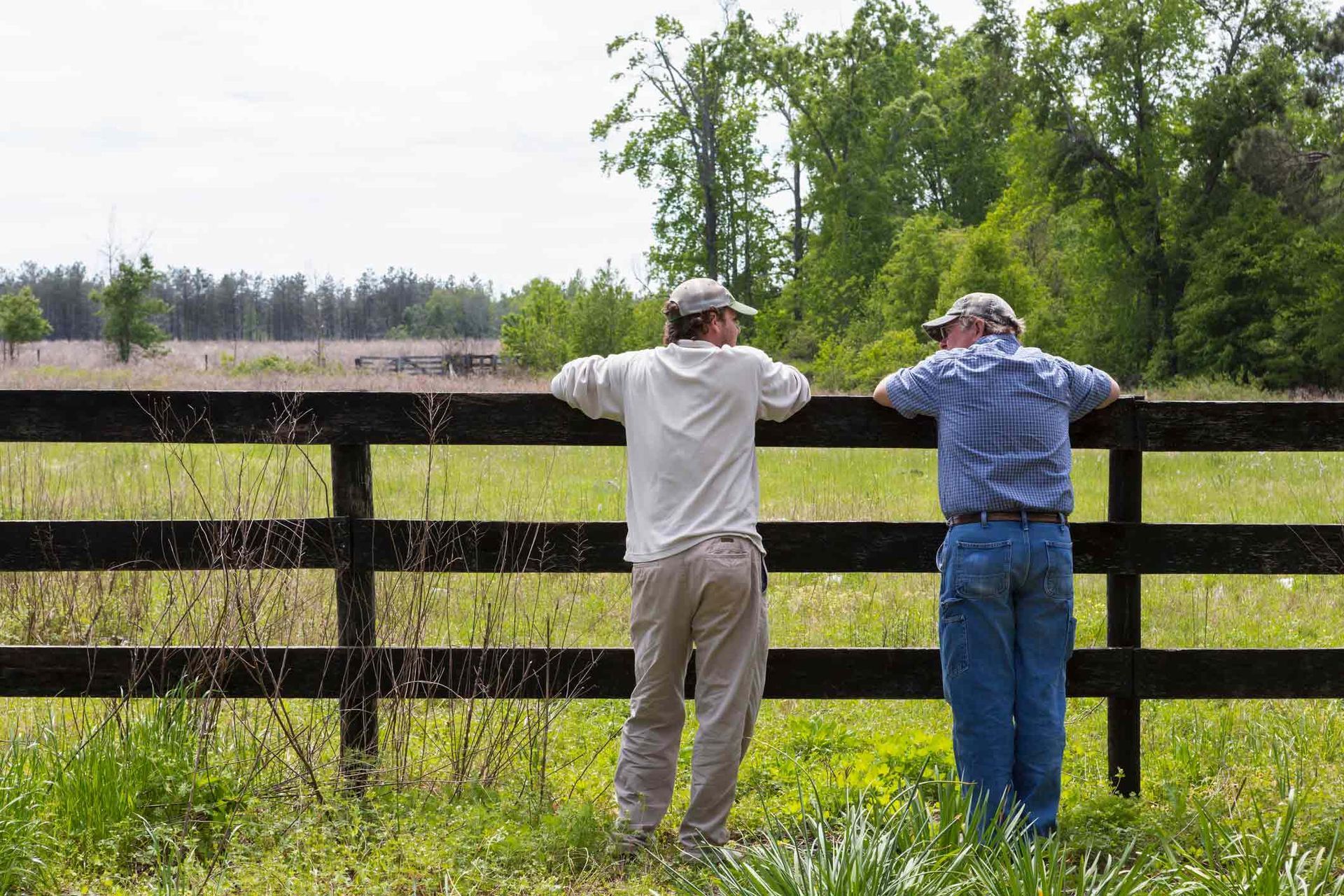 Two Men Are Leaning on A Fence in A Field | Cranbourne, VIC | Cranbourne Fencing Pty Ltd