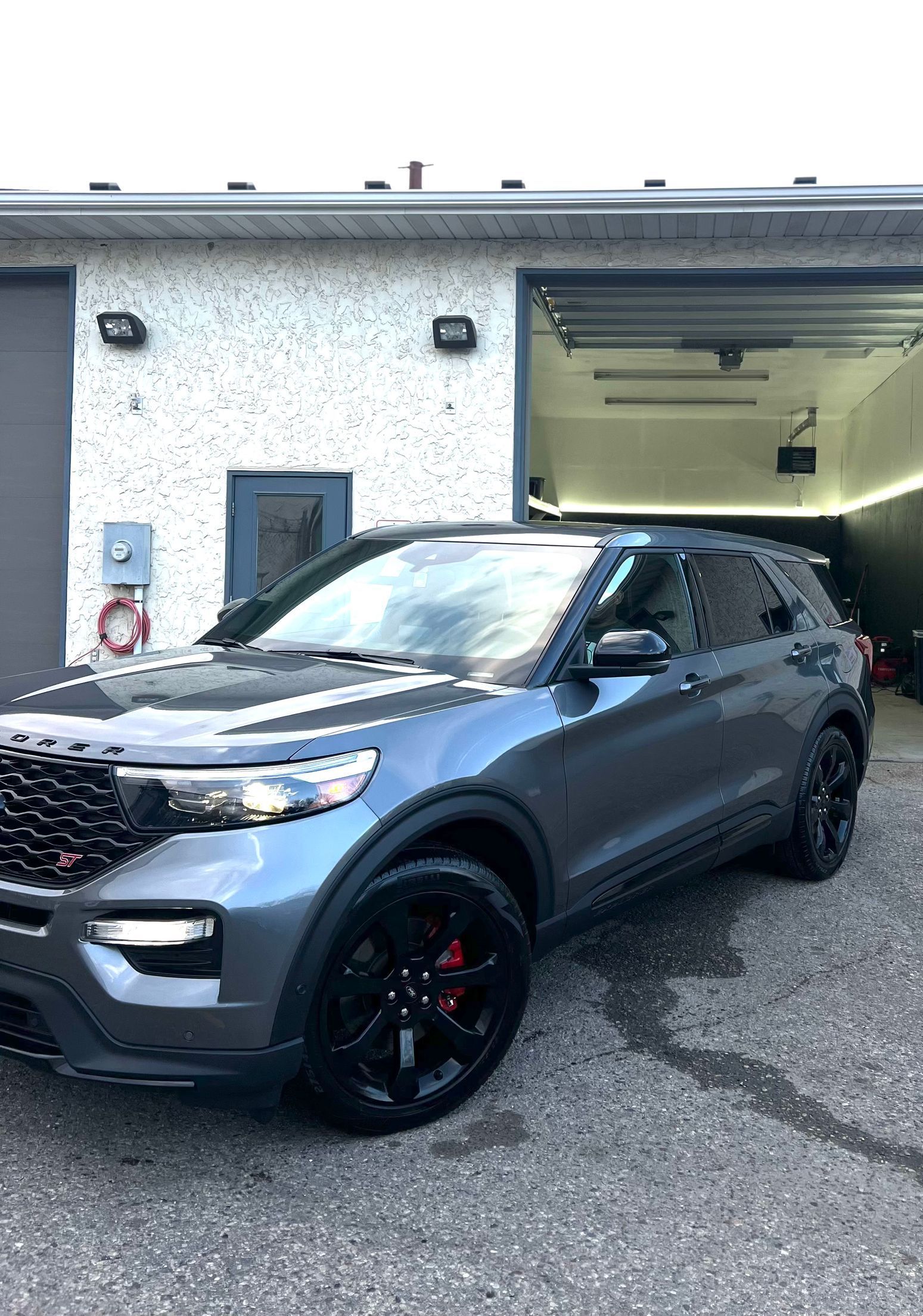 A ford explorer is parked in front of a garage.