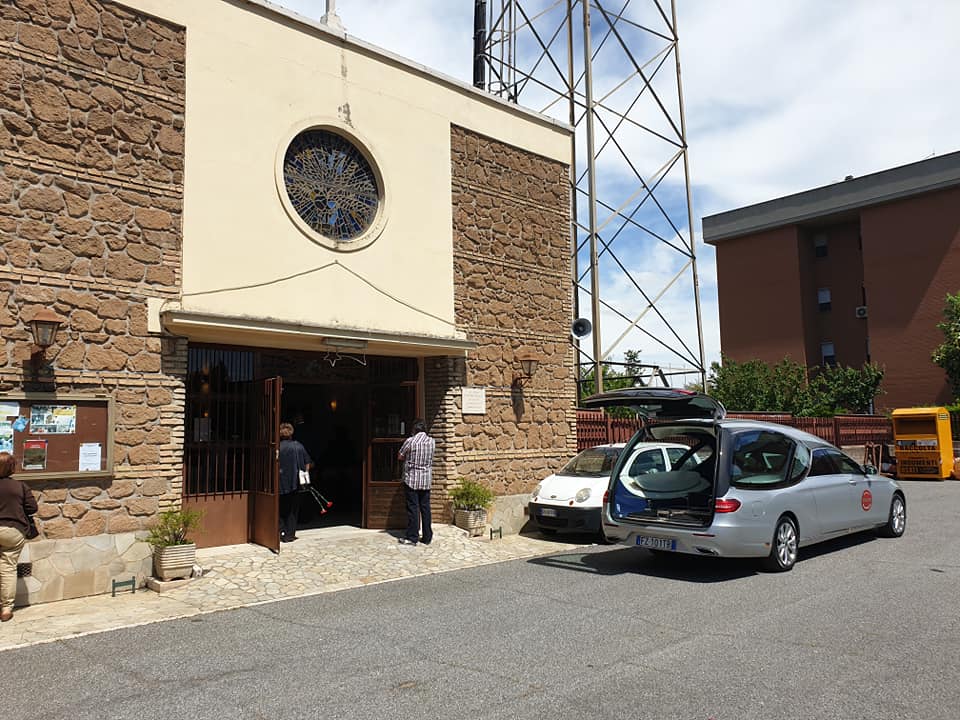 auto funebre grigia fuori da una chiesa