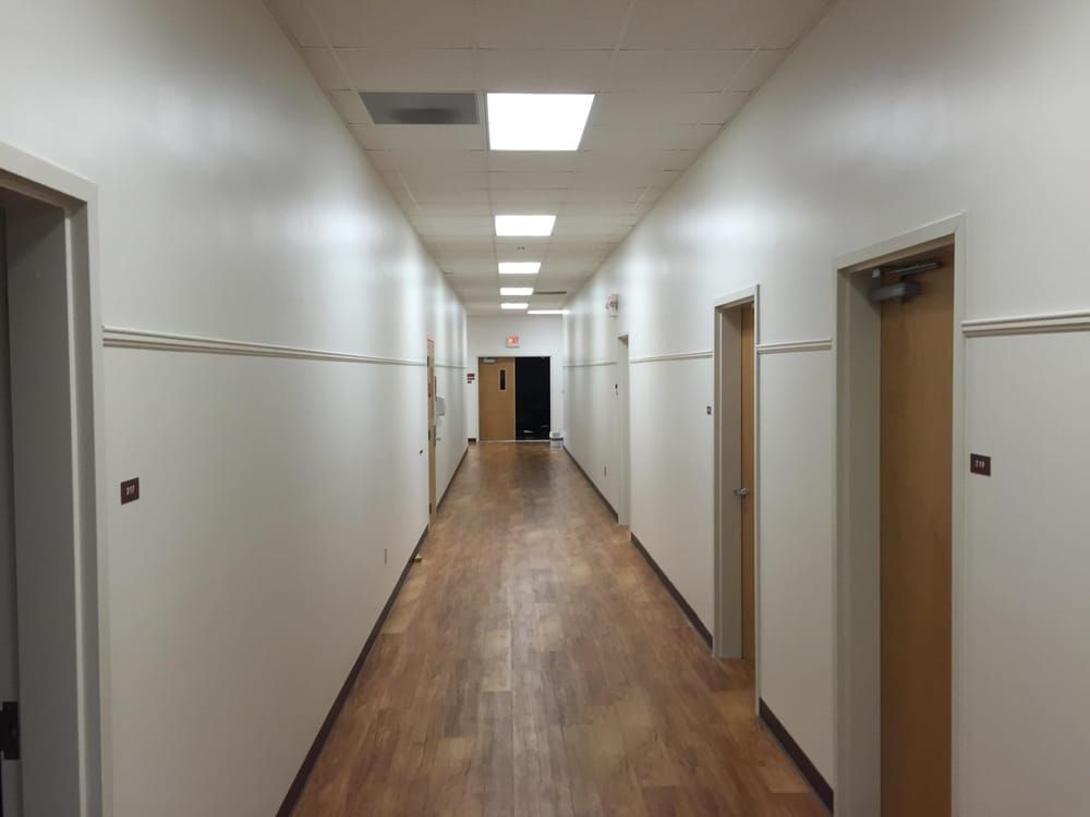 A long hallway with wooden floors and white walls