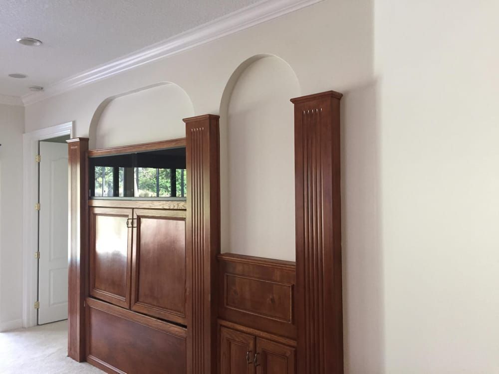 There is a large wooden cabinet in the middle of the room.