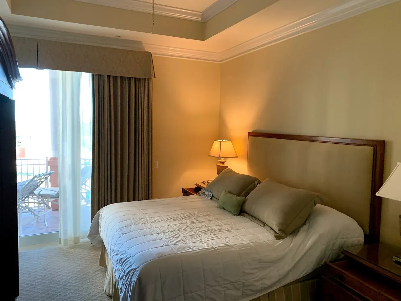 A hotel room with a large bed and a sliding glass door