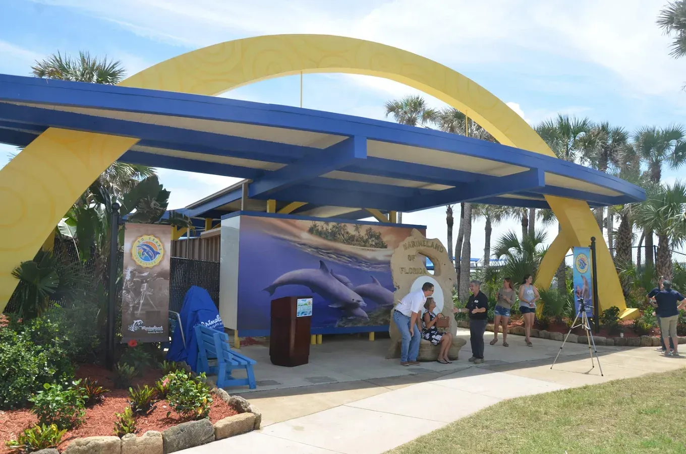 A blue and yellow building with a whale painting on it