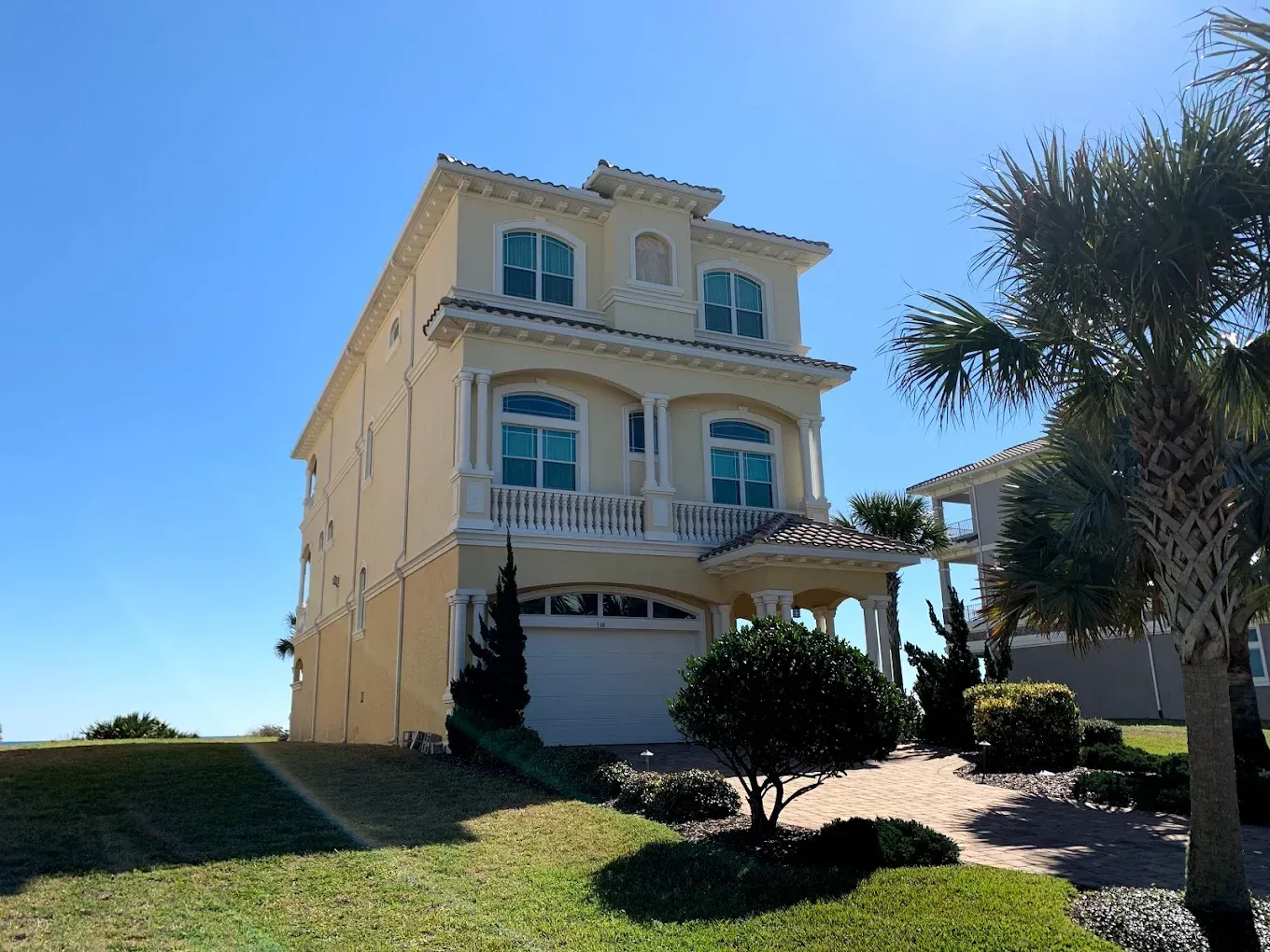 A large yellow house with a blue sky in the background