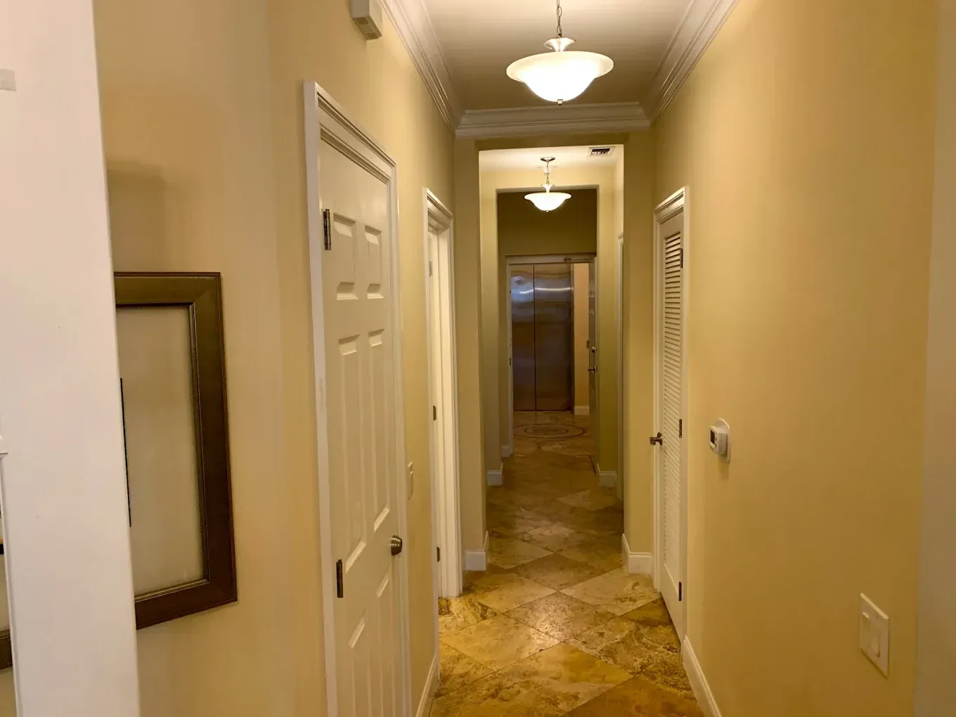 A long hallway in a house with a picture on the wall