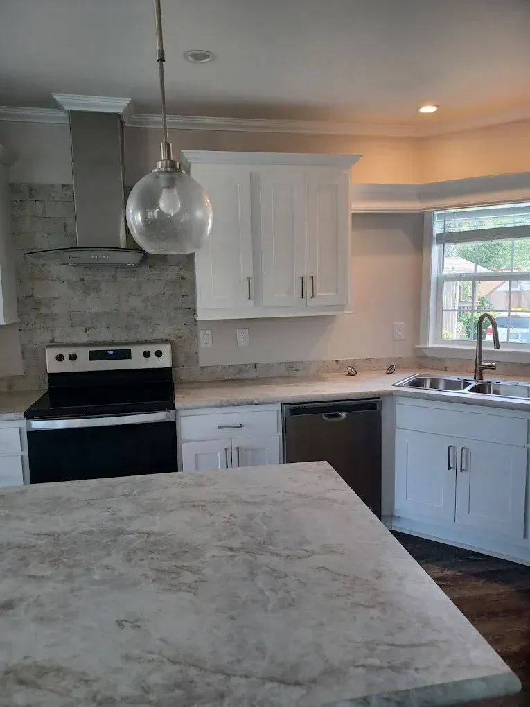 A kitchen with a stove , sink , and dishwasher.
