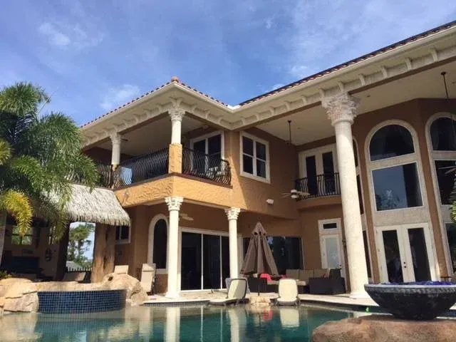 A large house with a swimming pool in front of it