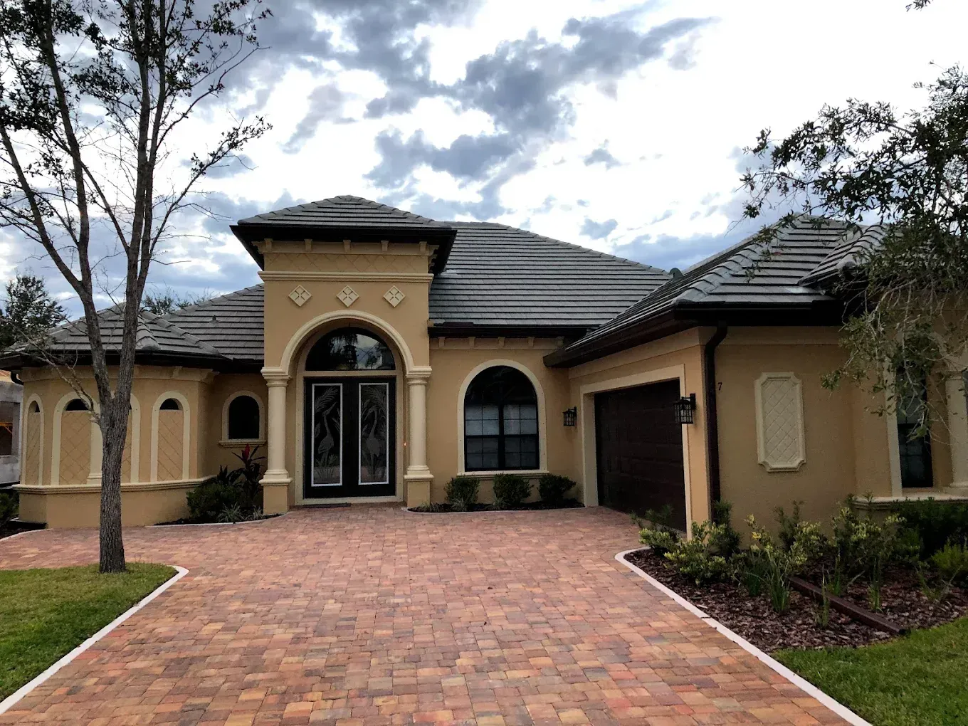 A large house with a brick driveway leading to it