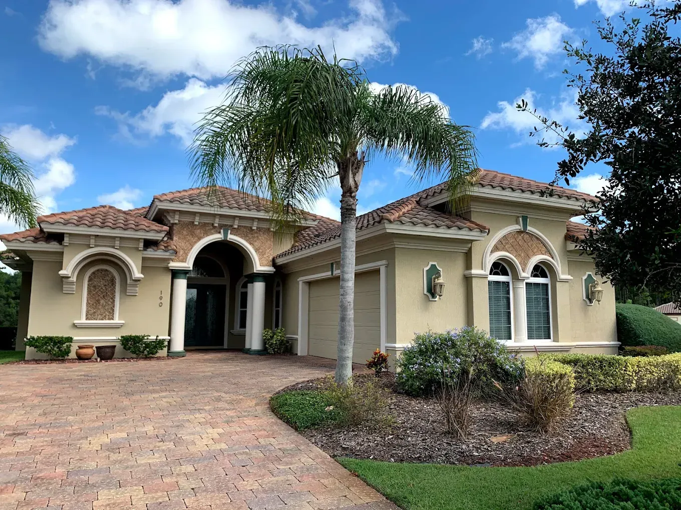 A large house with a palm tree in front of it