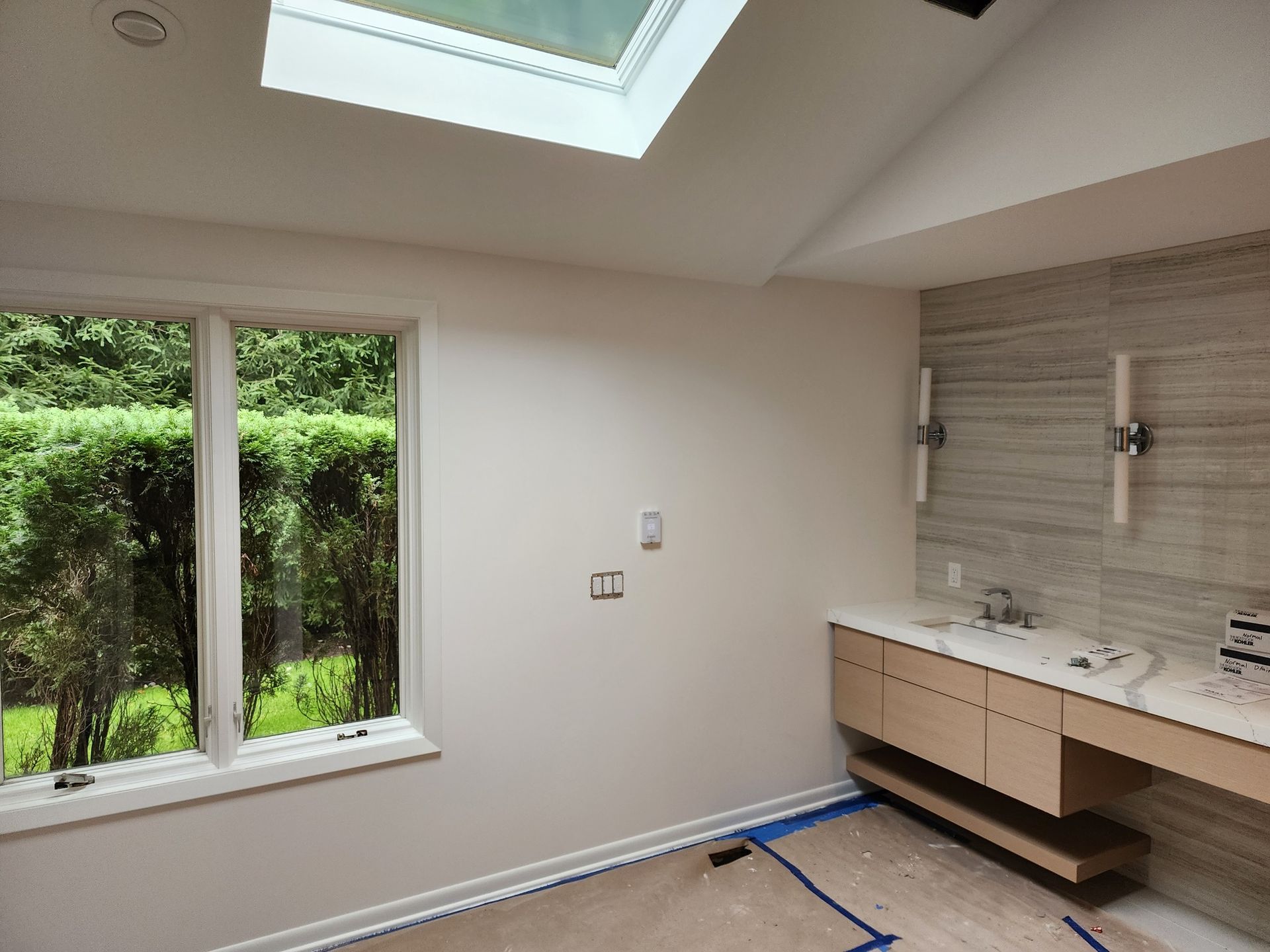 An empty bathroom with a skylight and two sinks